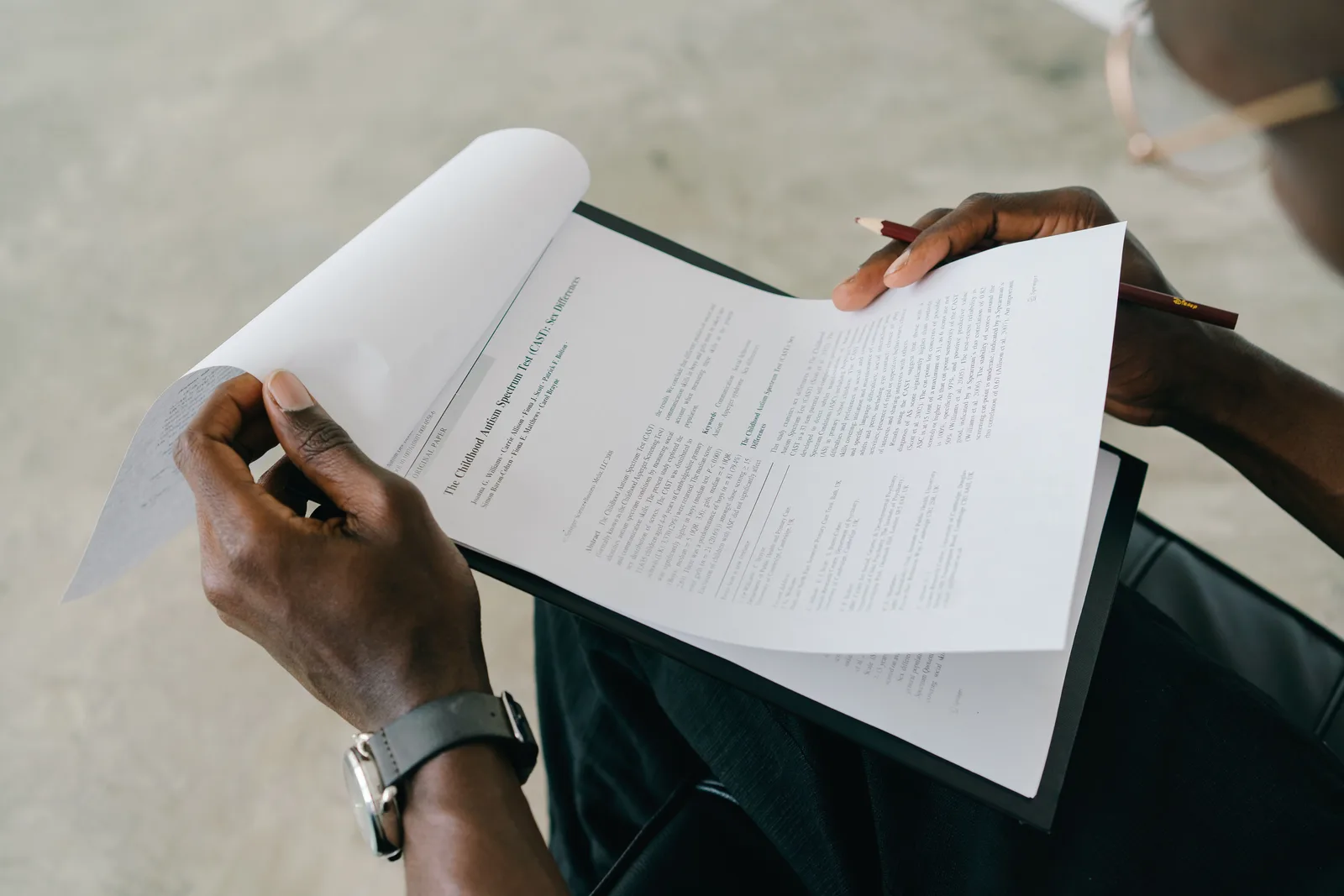 Hands holding and reviewing business documents with a pen, focusing on detailed paperwork. Ever scroll: CCPA and CPRA duties for online communities