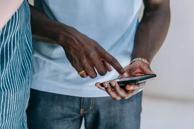 Close-up of a person interacting with a smartphone, captured indoors in a casual setting. Testing a digital community rule change against the evidence