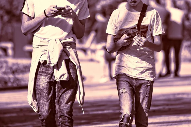 person, man, young man, guy, guys, two, two guys, friends, together, side by side, smartphone, walking, checking phone, outdoors, hand, holding phone, obsession, addicted, sunshine, sunny day, two guys, checking phone, holding phone, holding phone, holding phone, holding phone, obsession, obsession, obsession, obsession, obsession, addicted, addicted. Digital wellbeing and boundaries: a practical guide