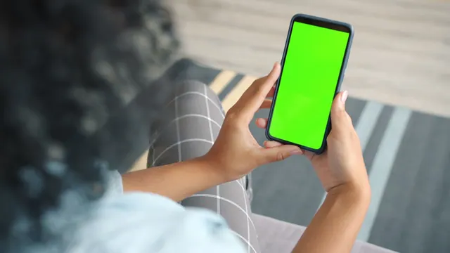 Close-up of a woman using a smartphone with a green screen for mockup indoors. What goes wrong when memes lose their context