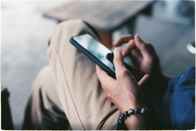 A close-up view of a person using a smartphone indoors, showcasing modern technology. Online identity and self-presentation: a practical guide