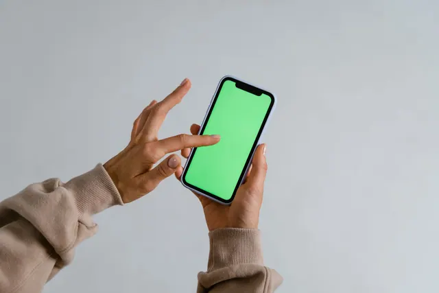 Hands interacting with a smartphone showcasing a vibrant green screen for multimedia use. A practical online identity and self-presentation checklist