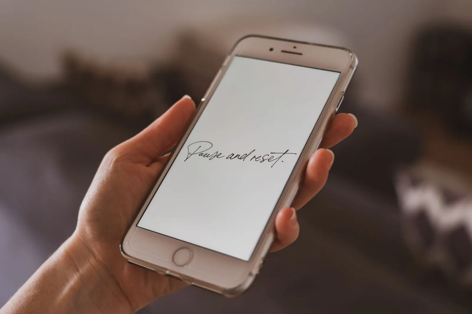 A hand holding a smartphone with a motivational quote on the screen, suggesting reflection. How to reset a scrolling habit without abandoning your phone