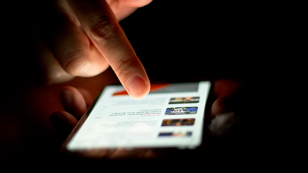 A person scrolling through news items on a smartphone
